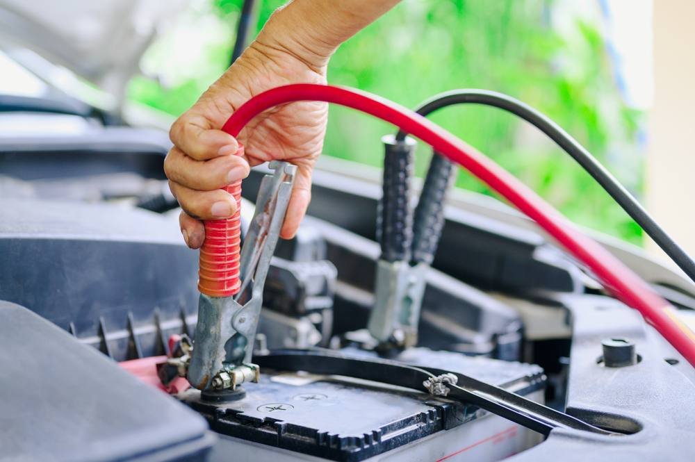 Jumper cables boosting a car battery