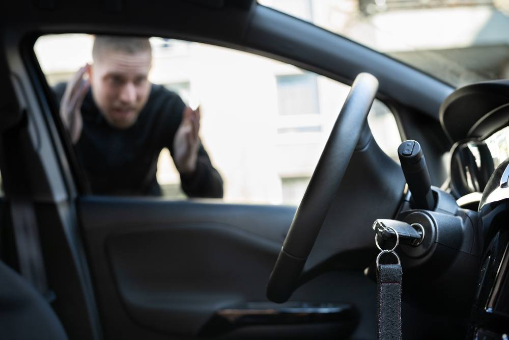 Driver looking at keys locked inside a car